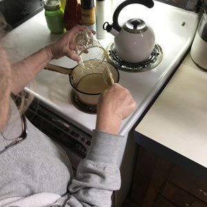 Adding ingredients to the saucepan for our stuffy nose syrup at the kitchen stove