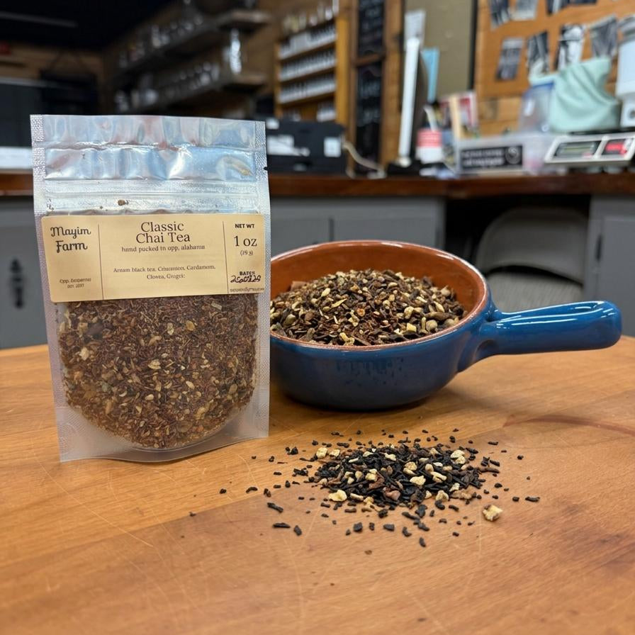 Classic Chai Tea in a 1 oz pouch beside a bowl of loose black tea and whole chai spices, hand packed at Mayim Farm in Opp, Alabama