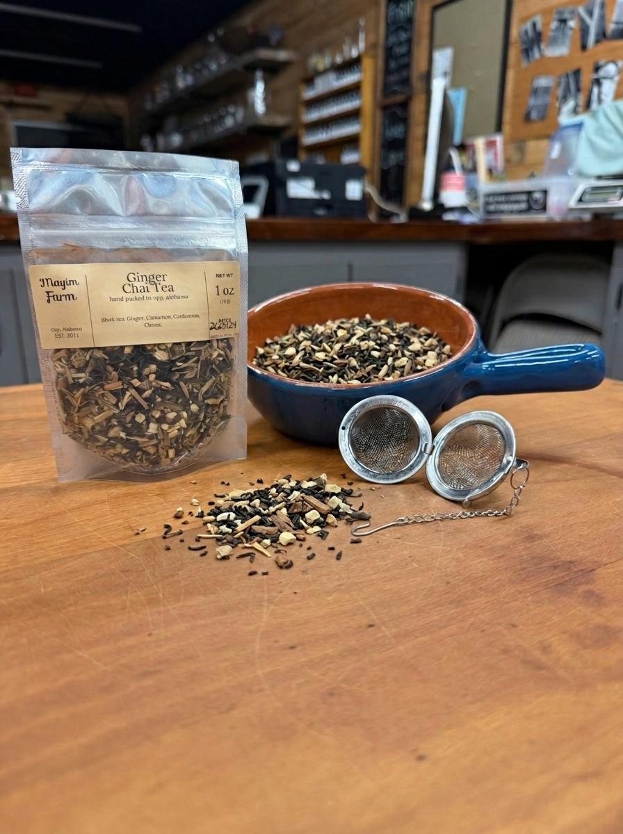 Ginger Chai Tea in a 1 oz pouch with a bowl of loose black tea, ginger and whole spices and a tea ball strainer, hand packed in Opp, Alabama
