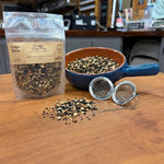 Ginger Chai Tea in a 1 oz pouch with a bowl of loose black tea, ginger and whole spices and a tea ball strainer, hand packed in Opp, Alabama