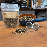 Ginger Chai Tea in a 1 oz pouch with a bowl of loose black tea, ginger and whole spices and a tea ball strainer, hand packed in Opp, Alabama
