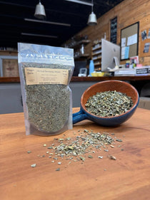 Herbal Smoking Blend in a 1 oz pouch beside a bowl of the loose mullein-based blend, hand-blended at Mayim Farm in Opp, Alabama