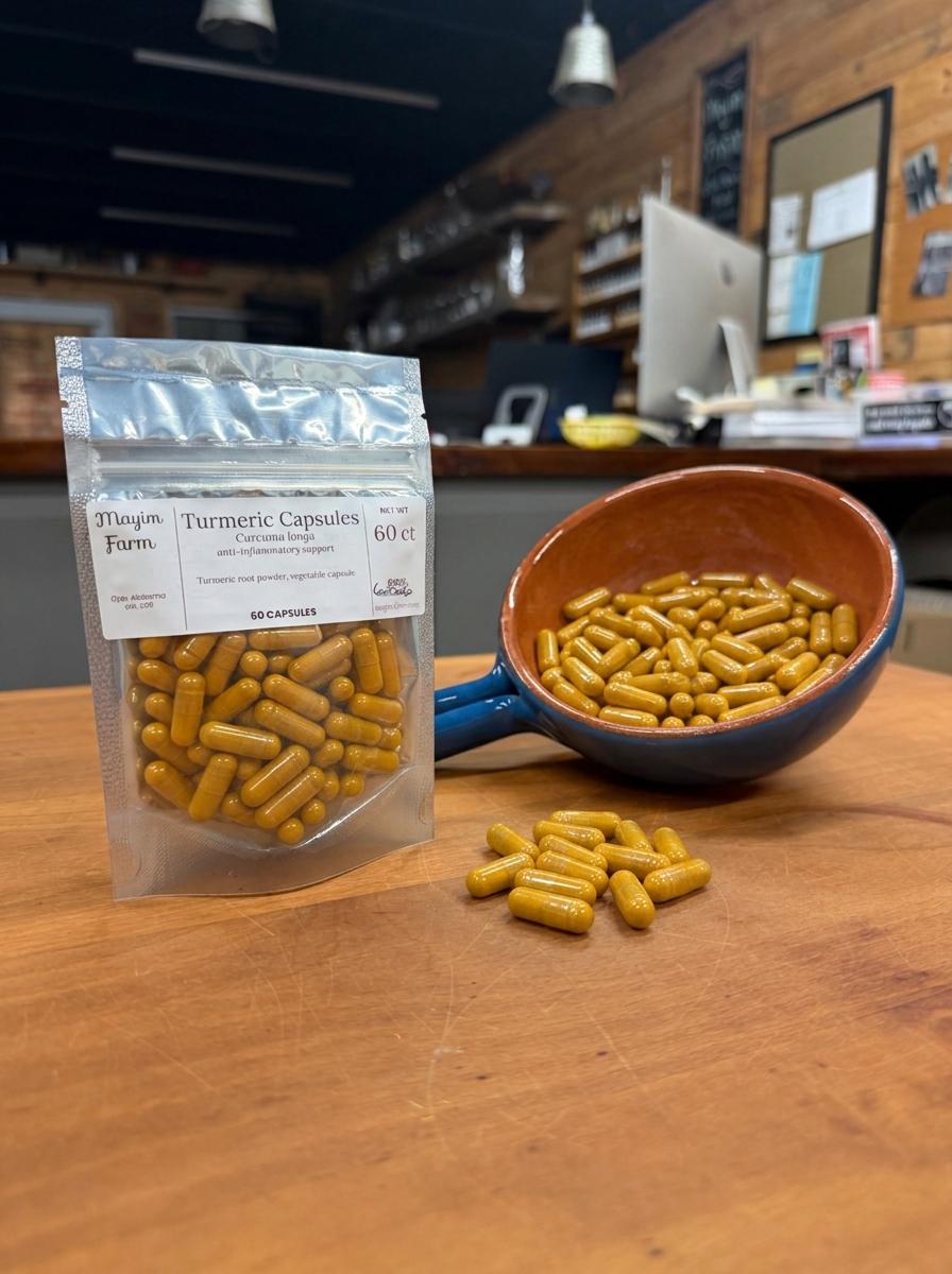 Turmeric Capsules, 60 count, beside a bowl of loose capsules, hand-filled at Mayim Farm in Opp, Alabama