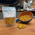 Turmeric Capsules, 60 count, beside a bowl of loose capsules, hand-filled at Mayim Farm in Opp, Alabama