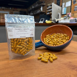 Turmeric Capsules, 60 count, beside a bowl of loose capsules, hand-filled at Mayim Farm in Opp, Alabama
